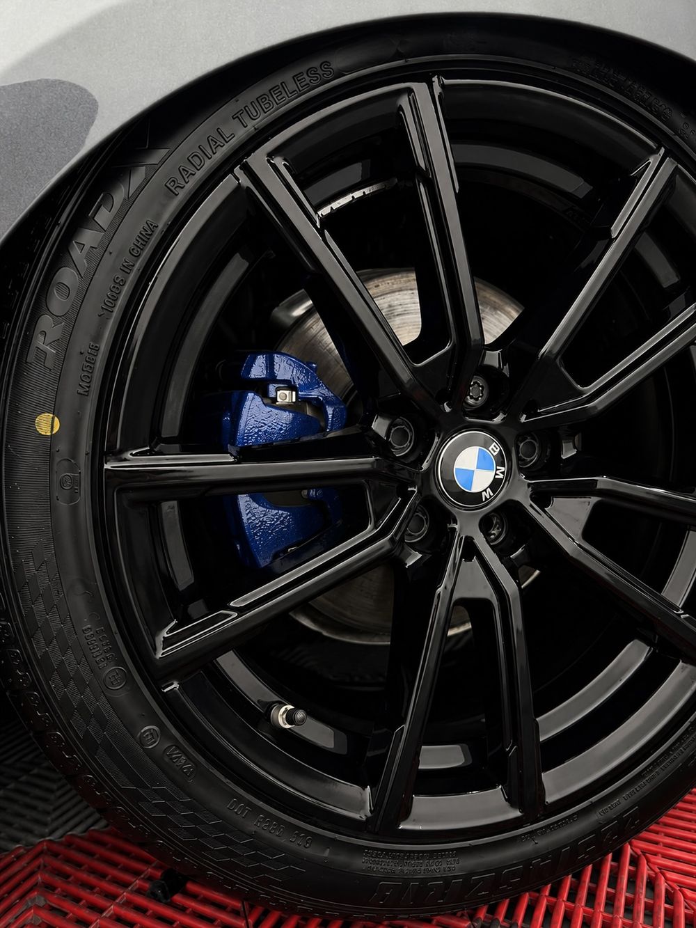 Roda preta da BMW com pinça azul após limpeza técnica detalhada